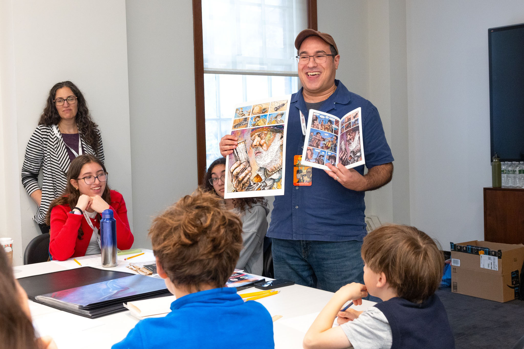 man showing comics to a class.