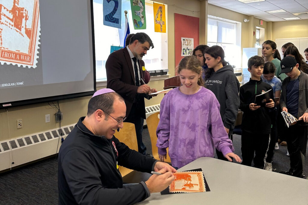 man sigining comics for kids.