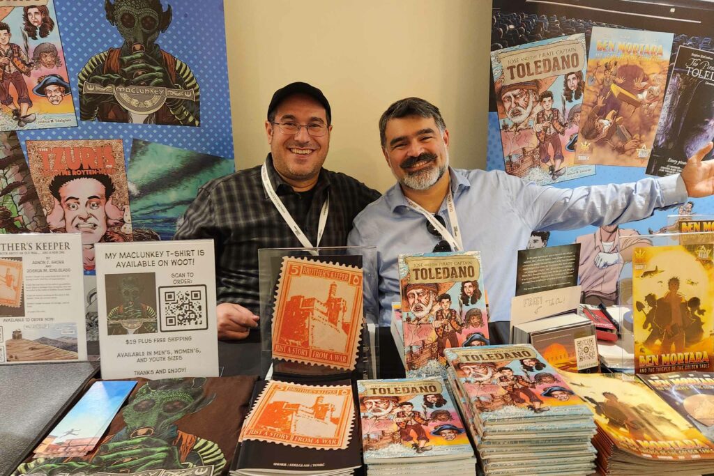 two men showing comics at a table.